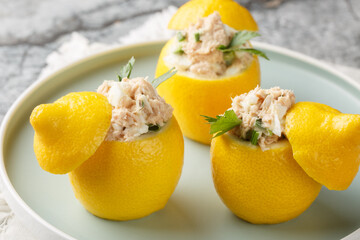 Wall Mural - Mediterranean Tuna Salad Stuffed Lemons closeup on the plate on the table. Horizontal