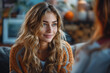 © Laurent - a young woman with wavy hair smiling and talking in a cozy office setting with warm lighting and a friendly atmosphere