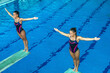© Microgen - Female divers on the jumping board, showcasing their strength and agility. Precision and focus required for competitive diving.