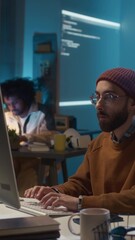 Vertical shot of young Caucasian male software developer discussing joint IT project workflow with female colleague at workplace in office