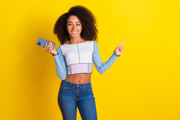 Sticker - Photo portrait of lovely young lady hold device point empty space dressed stylish blue garment isolated on yellow color background