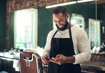 barber, happy and man with phone in salon for internet, social media and website for beauty service.