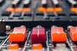 © Sved Oliver - Closeup shot of a professional audio mixer with colorful faders in a studio setting