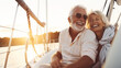 © halo - smiling happy senior couple on a sailboat or yacht enjoying the sea at sunset