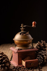 vintage coffee grinder, filled with coffee beans that you grind by turning the crank.