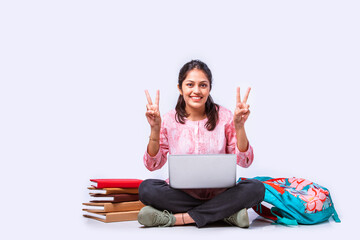 Wall Mural - Indian asian pretty young female student studying sitting on white backgrounds