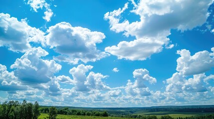 blue sky with white clouds and treetops in the landscape