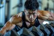 © anzodesign - Asian man lifting weights in a gym