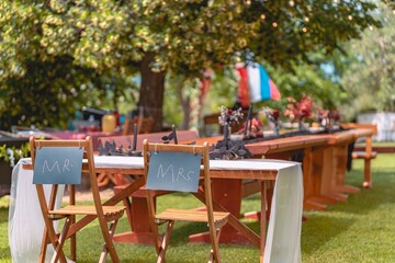 Wall Mural - Outdoor wedding reception setup with Mr. and Mrs. signs on chairs