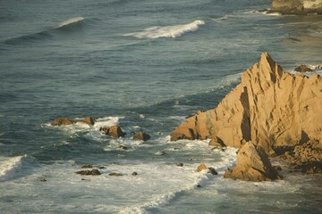 Wall Mural - A scenic view of rocky coastline with waves crashing on the shore