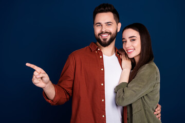 Wall Mural - Photo of cheerful lovely attractive couple wife husband stylish clothes recommend empty space isolated on dark blue color background