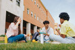 © Alberto - Three multiethnic students sitting in campus having lunch and enjoying friendship.