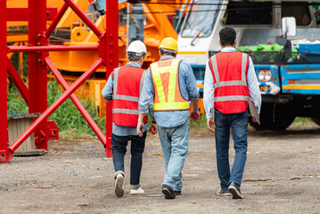 Wall Mural - Foreman and worker on construction crane inspection is made to transport the crane from storage to be assembled on the building construction site