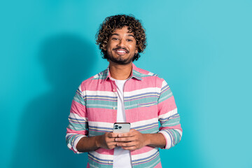 Sticker - Photo of cheerful positive curly hair man wear trendy striped clothes isolated on cyan color background