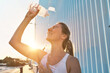 © Andrii IURLOV - Athletic Woman Drinks water and Splashes Water on Her Face After Intense Exercise, Post-Run Refreshment, Summer Fitness Hydrating and Cooling Off During a Hot Day Run
