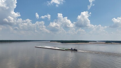 Shipping and commerce on the Mississippi River with boats  transporting  barges with products to various cities 