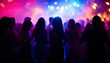 © abu - silhouettes of people dancing at a crowded party at midnight, colorful lights and smoke at background