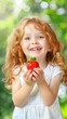 © volga - Smiling young caucasian girl holding fresh strawberry in summer