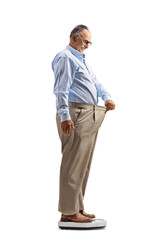 Canvas Print - Mature man trying on an old pair of pants and weighing on a scale