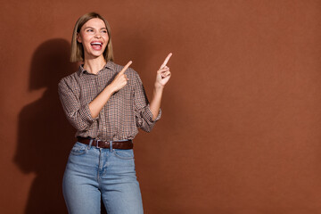 Poster - Photo of lovely crazy cheerful woman wear stylish clothes look empty space isolated on brown color background