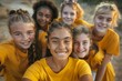 © Baba Images - Diverse group of young girls with yellow shirts taking a selfie