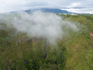 Wall Mural - Aerial view of a waterfall covered in mist