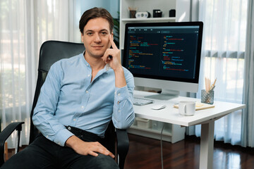 IT developer looking camera with online software development information on pc and laptop monitor beside, coding program on updated version application project creating new code system. Pecuniary.