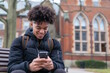 © MarGa - Teenage boy using a smartphone while sitting on a bench, representing connectivity and social media. Concept for modern communication, suitable for Safer Internet Day