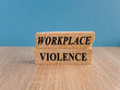 © Liudmila - WORKPLACE VIOLENCE symbol. Concept words WORKPLACE VIOLENCE on brick blocks. Beautiful blue background, wooden table. Business concept. Copy space.