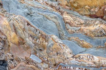 Wall Mural - Close-up of colorful layered rock formations with intricate patterns and textures