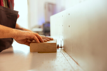 Wall Mural - Man using edge jointer in assembly studio, performing specialized cuts, making wooden objects, close up shot. Focus on spindle moulder used by cabinetmaker for smoothing out panels