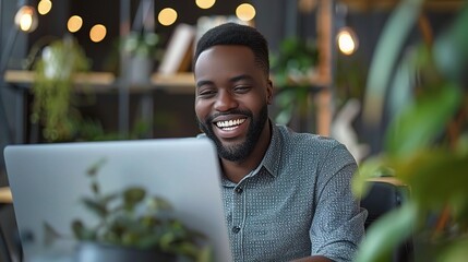 Wall Mural - Smiling Businessman: A portrait of a happy and successful businessman working on his laptop in a modern office setting.  He exudes confidence and professionalism