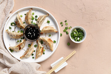 Sticker - Plate with fried Japanese gyoza and bowl of soy sauce on beige background