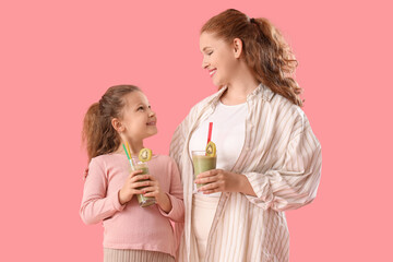 Sticker - Mother and little daughter with glasses of smoothie on pink background