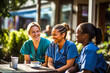 © Garnar - Women nurses, diverse ethnicities, chatting on coffee break outdoors. Medical professional in uniforms enjoying time together. Concept of healthcare workers supporting each other and managing stress