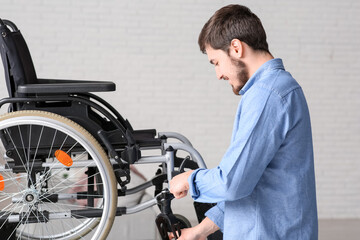 Poster - Young man repairing wheelchair on table at home