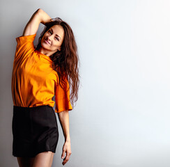 Wall Mural - Beautiful relaxing happy casual woman in bright orange t-shirt looking on blue studio background on empty copy space. Closeup