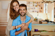 © peopleimages.com - Portrait, home and couple with smile, hug and happiness with romance, connect and relationship. Face, apartment and man with woman, marriage and commitment with embrace and time together in lounge