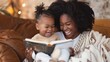 © Ilia Nesolenyi - A young woman and her toddler daughter share a book and laughter while sitting on a brown sofa in a warm, inviting living room