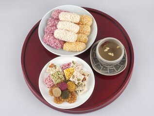 Close-up of Korean traditional sweets and cookies with ginger tea on teacup and wood tray, South Korea
