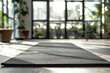 © YULIYA - Yoga mat on wooden floor in modern fitness studio, closeup.