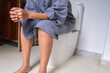© Photo Sesaon - woman sitting on the toilet bowl in the bathroom. she has stomach ache. Poor digestive system. Constipation. Diarrhea. Food poisoning. Health and medicine