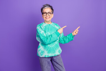 Poster - Photo portrait of lovely pensioner lady point empty space dressed stylish green garment isolated on purple color background