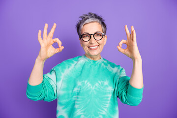 Poster - Photo portrait of lovely pensioner lady show okey approve dressed stylish green garment isolated on purple color background