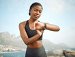 © peopleimages.com - Sports, athlete and black woman on jog, watch and break in nature, beach and fitness for runner. Ocean, exercise and person with smile for timer, wellness and workout of running in weekend and happy