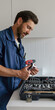 © Daria - Professional handyman with tool bag standing on home kitchen background
