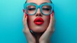 © Nataliia_Trushchenko - A woman with blue glasses and red lipstick. She is holding her hands together. The image has a bright and cheerful mood