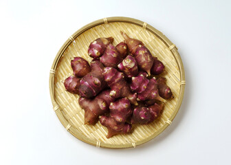 Poster - Close-up and top angle view of stacked raw red roots of Jerusalem artichoke on bamboo basket, South Korea
