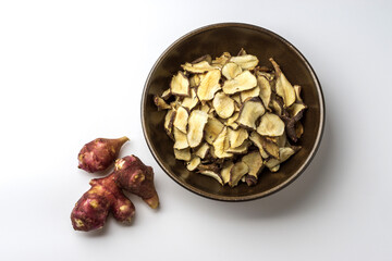 Poster - Close-up of three raw red roots of Jerusalem artichoke with stacked dried others on a jar, South Korea
