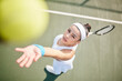 © Fanti/peopleimages.com - Bat, ball and woman with serve on tennis court for outdoor warm up, workout or practice match. Fitness, exercise and professional athlete girl in game with racket, competition and sports from above